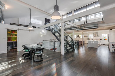 Example of a large urban dark wood floor and brown floor great room design in Toronto with white walls and no fireplace
