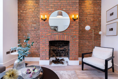 Medium sized living room in London with medium hardwood flooring and a brick fireplace surround.