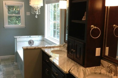 Large trendy master multicolored tile and stone tile marble floor bathroom photo in Other with raised-panel cabinets, dark wood cabinets, a two-piece toilet, green walls, an undermount sink and marble countertops