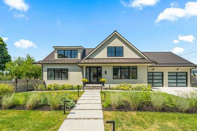 Mid-sized transitional beige two-story concrete fiberboard and clapboard exterior home photo in Bridgeport with a metal roof and a brown roof