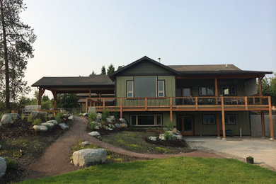 Photo of a country two-storey green exterior in Other with mixed siding.