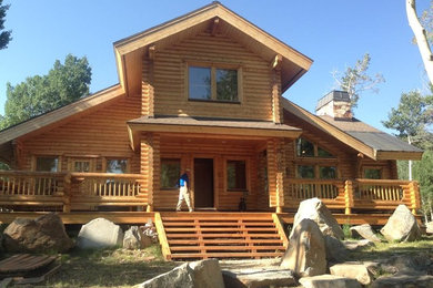 Diseño de fachada de casa marrón rústica grande de dos plantas con revestimiento de madera y tejado de teja de madera