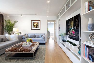 Inspiration for a mid-sized transitional open concept light wood floor and beige floor living room remodel in New York with white walls, no fireplace and a media wall