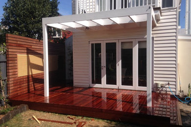 This is an example of a mid-sized arts and crafts backyard deck in Melbourne with a pergola.
