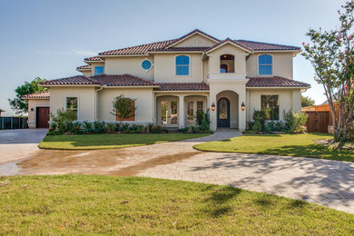 Inspiration for a large mediterranean beige three-story exterior home remodel in Dallas