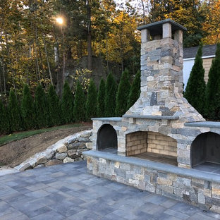 Großer Stilmix Hanggarten im Sommer mit Kamin, direkter Sonneneinstrahlung und Pflasterklinker in Boston