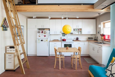 Example of a mid-sized trendy l-shaped ceramic tile and red floor eat-in kitchen design in Albuquerque with flat-panel cabinets, white cabinets, white backsplash, white appliances, no island, a double-bowl sink and wood countertops