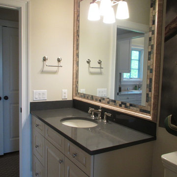 Bathroom Vanity with Dark Countertop and Framed Mirror