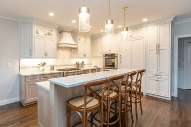 Mid-sized transitional l-shaped brown floor and medium tone wood floor eat-in kitchen photo in Boston with an undermount sink, beaded inset cabinets, light wood cabinets, quartz countertops, white backsplash, cement tile backsplash, stainless steel appliances, an island and white countertops