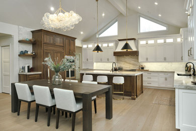 Inspiration for a huge transitional u-shaped light wood floor, gray floor and vaulted ceiling open concept kitchen remodel in San Francisco with an undermount sink, beaded inset cabinets, white cabinets, quartzite countertops, white backsplash, marble backsplash, paneled appliances, an island and gray countertops
