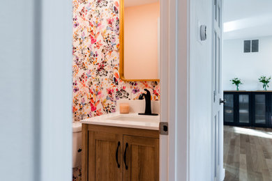 Example of a mid-sized transitional powder room design in Seattle with medium tone wood cabinets and a freestanding vanity