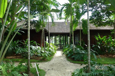 Example of a large island style one-story wood house exterior design with a hip roof and a tile roof