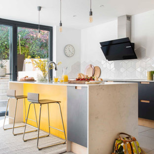 Photo of a large contemporary galley kitchen in Sussex with flat-panel cabinets, black cabinets, white splashback, porcelain splashback, porcelain flooring, an island, grey floors and beige worktops.