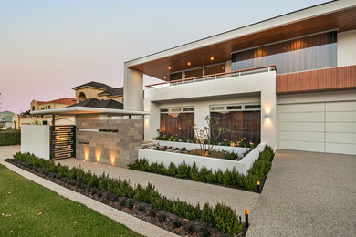 Inspiration for a contemporary two-storey stucco beige house exterior in Perth with a flat roof.