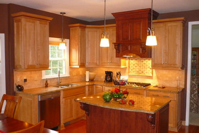 Example of a mid-sized arts and crafts l-shaped medium tone wood floor and brown floor eat-in kitchen design in Other with an undermount sink, raised-panel cabinets, light wood cabinets, granite countertops, beige backsplash, stainless steel appliances, an island and stone tile backsplash