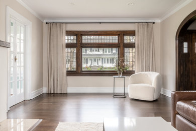 Großes, Abgetrenntes Klassisches Wohnzimmer mit beiger Wandfarbe, dunklem Holzboden, Kamin, verputzter Kaminumrandung, TV-Wand und braunem Boden in New York