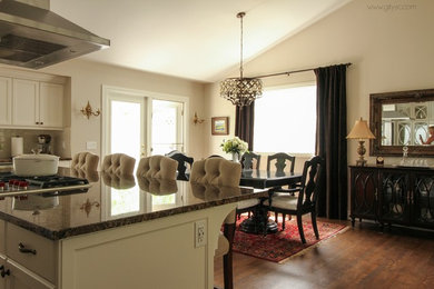 Eat-in kitchen - large transitional l-shaped medium tone wood floor and brown floor eat-in kitchen idea in Calgary with an undermount sink, shaker cabinets, white cabinets, granite countertops, white backsplash, ceramic backsplash, stainless steel appliances and an island