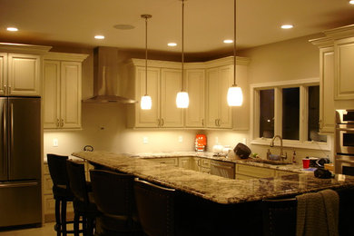 Inspiration for a kitchen remodel in New York with an undermount sink, raised-panel cabinets, beige cabinets, granite countertops, stainless steel appliances and an island