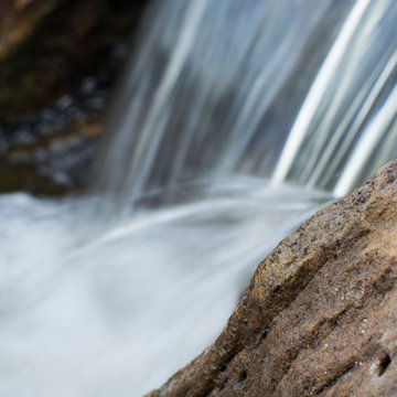 Rustic Mountain stream flowing into lakeside patio