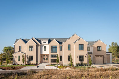 Inspiration for a contemporary beige two-story brick exterior home remodel in Denver with a shingle roof and a gray roof