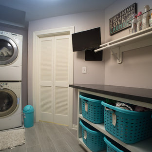 Inspiration for a medium sized traditional galley separated utility room in Indianapolis with open cabinets, composite countertops, purple walls, vinyl flooring, a stacked washer and dryer and grey floors.