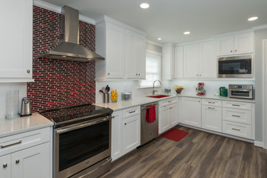 Inspiration for a large contemporary l-shaped medium tone wood floor, brown floor and tray ceiling eat-in kitchen remodel in Richmond with a double-bowl sink, flat-panel cabinets, white cabinets, quartzite countertops, red backsplash, mosaic tile backsplash, stainless steel appliances, no island and white countertops