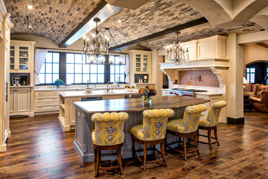 Example of a classic dark wood floor and brown floor kitchen design in Minneapolis with recessed-panel cabinets, beige cabinets, red backsplash, stainless steel appliances, two islands and white countertops