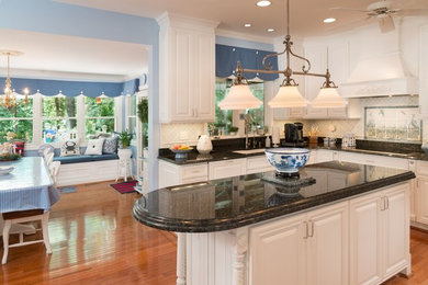 Example of a large trendy l-shaped medium tone wood floor and brown floor kitchen pantry design in San Francisco with a drop-in sink, raised-panel cabinets, white cabinets, laminate countertops, gray backsplash, ceramic backsplash, white appliances and an island