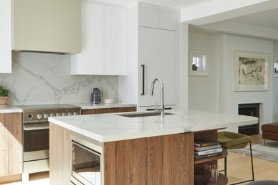 Example of a mid-sized minimalist light wood floor eat-in kitchen design in Toronto with an undermount sink, flat-panel cabinets, quartz countertops, white backsplash, quartz backsplash, paneled appliances, an island and white countertops