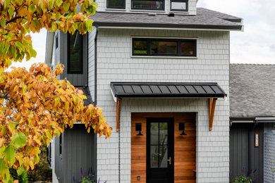 Modelo de fachada de casa gris y gris marinera de dos plantas con revestimientos combinados, tejado de un solo tendido, tejado de varios materiales y teja