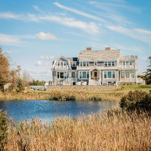 На фото: двухэтажные фасады частных домов серого цвета в морском стиле с облицовкой из дерева, мансардной крышей и крышей из гибкой черепицы