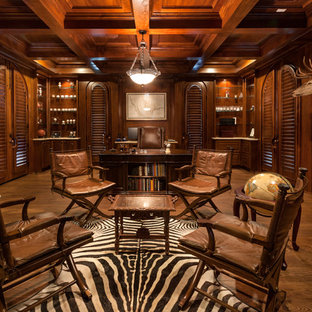 Inspiration for an expansive country study room in Houston with brown walls, medium hardwood floors, a standard fireplace, a freestanding desk and a plaster fireplace surround.
