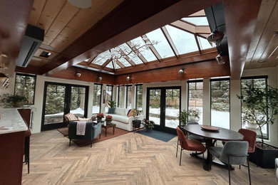 Large elegant medium tone wood floor and brown floor sunroom photo in Boston with a glass ceiling