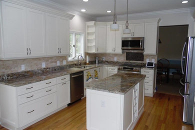 Enclosed kitchen - mid-sized transitional u-shaped light wood floor and brown floor enclosed kitchen idea in Baltimore with an undermount sink, recessed-panel cabinets, white cabinets, granite countertops, beige backsplash, porcelain backsplash, stainless steel appliances, an island and beige countertops