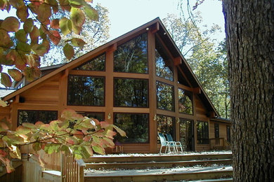 Mid-sized contemporary brown two-story wood exterior home idea in Other with a shingle roof
