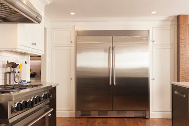 Transitional kitchen photo in Toronto with shaker cabinets, white cabinets, quartz countertops, white backsplash, stainless steel appliances and an island