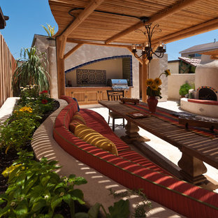 Design ideas for an expansive eclectic backyard patio in San Diego with an outdoor kitchen, natural stone pavers and a pergola.