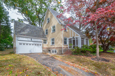 Large transitional beige three-story stucco exterior home idea in Philadelphia with a gambrel roof