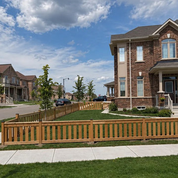 36 inch pressure-treated picket fence enclosing a front yard on a corner lot in