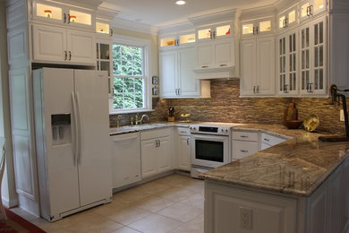 Inspiration for a mid-sized timeless u-shaped ceramic tile kitchen remodel in Other with white cabinets, granite countertops, brown backsplash, white appliances and a double-bowl sink