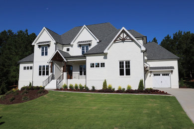 Huge craftsman white two-story brick exterior home idea in Raleigh with a shingle roof