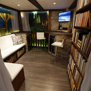 This is an example of a small coastal fully buried basement in Toronto with no fireplace and dark hardwood flooring.