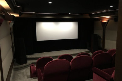 Inspiration for a large mid-century modern enclosed carpeted home theater remodel in Columbus with beige walls and a projector screen
