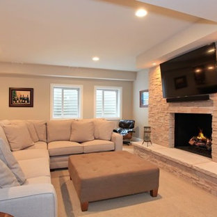 Photo of a large victorian fully buried basement in Chicago with beige walls, carpet, a standard fireplace and a stone fireplace surround.