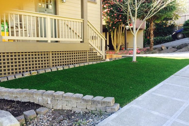 This is an example of a small traditional front yard full sun garden for summer in Seattle with concrete pavers.