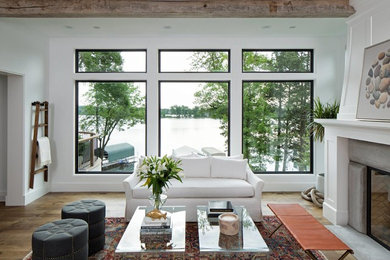 Design ideas for a large transitional living room in Boston with white walls, medium hardwood floors, a standard fireplace, a concrete fireplace surround and brown floor.