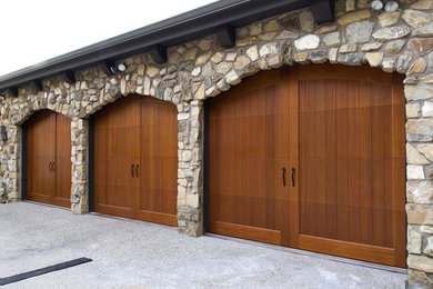 This is an example of a large contemporary attached three-car garage in Phoenix.