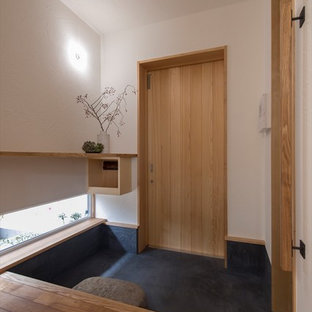 東京23区の片開きドア和風のおしゃれな玄関 (白い壁、淡色木目調のドア、黒い床) の写真