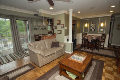 Inspiration for a mid-sized timeless open concept medium tone wood floor family room remodel in DC Metro with green walls, a two-sided fireplace, a stone fireplace and a wall-mounted tv