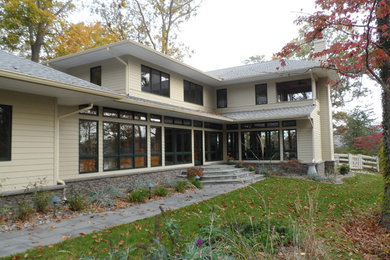 Large trendy beige two-story vinyl exterior home photo in Baltimore